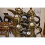 A graduated set of seven Eastern brass jugs, the largest 53 cm high, the smallest 25 cm high (7)