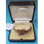 A French 18ct gold bangle, with a horseshoe set diamonds, unmarked, in a C Clerc, 4 Pge De L'
