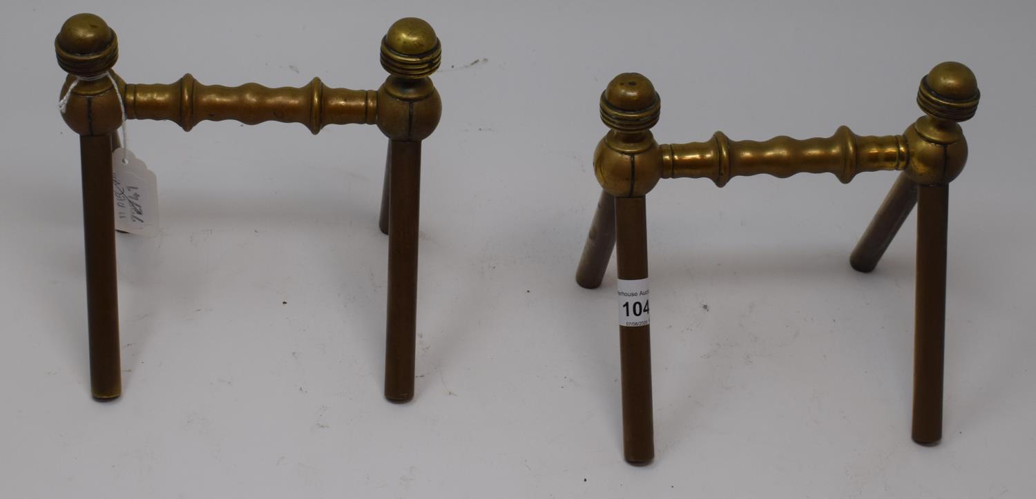 A pair of late 19th century Arts and Crafts brass fire dogs, with turned finials and turned