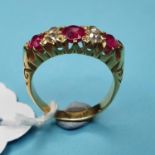 A yellow coloured metal, diamond and ruby ring, having three rubies interspersed by four diamonds,