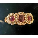 An 18ct gold, ruby and diamond triple flowerhead ring, approx. ring size N