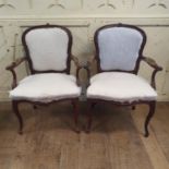 A pair of walnut armchairs, in the French taste, the arms carved scrolling foliage, on cabriole