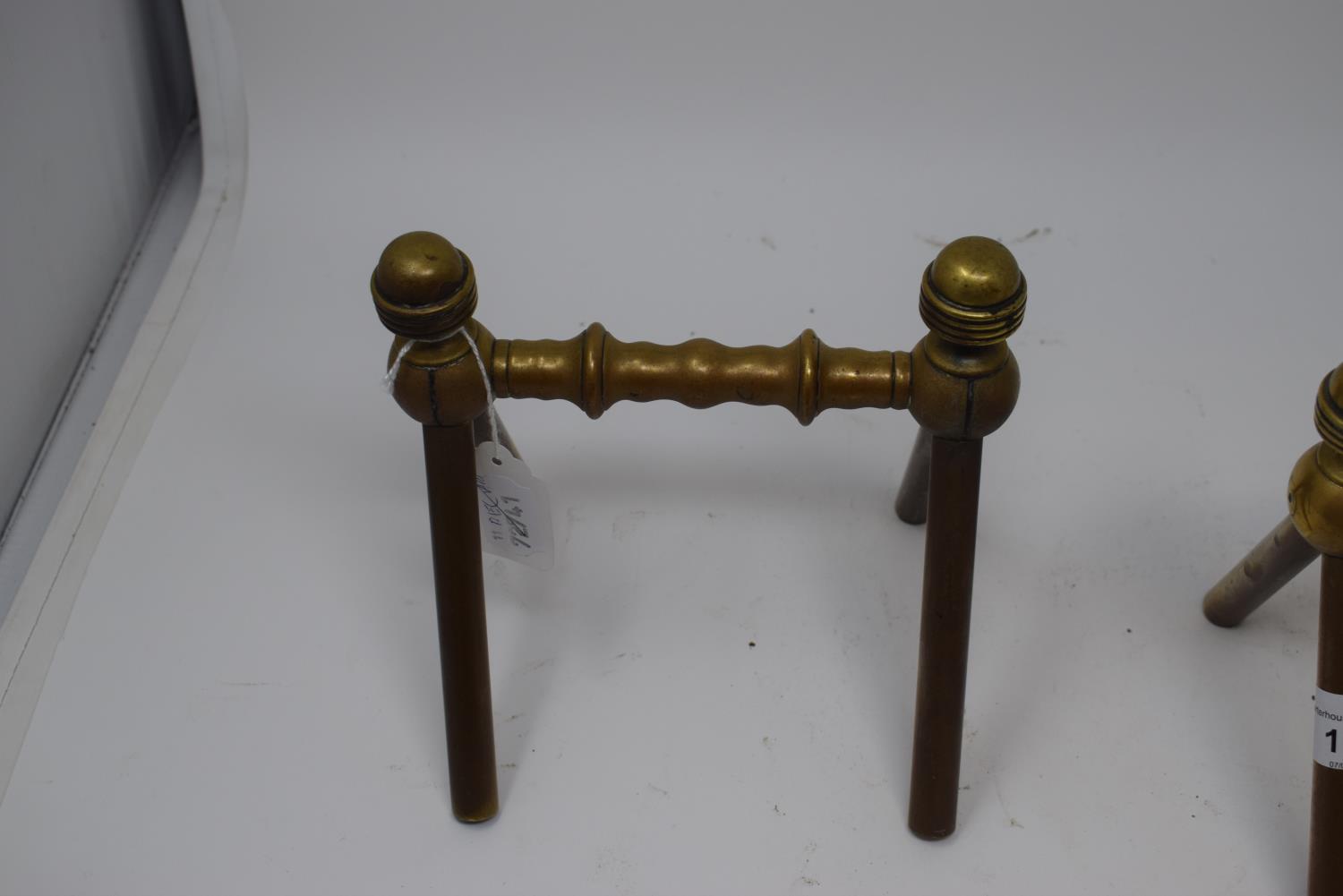 A pair of late 19th century Arts and Crafts brass fire dogs, with turned finials and turned - Image 2 of 2