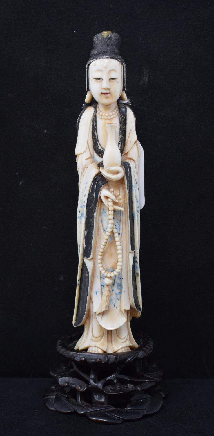 An early 20th century Chinese carved, stained and painted ivory figure, of a lady holding beads