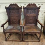 A pair of 18th century style carved oak wainscot armchairs, with solid seats and turned front legs