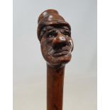 A 19th century one piece fruit wood walking stick handle in the form of a Dickensian type