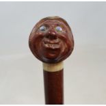 A 19th century fruit wood walking stick, with coquille nut handle, carved in the form of a grotesque