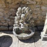 A composite stone fountain, in the form of a cherub standing on a shell 88 cm high