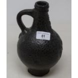 An 18th century German Belamine stoneware jug, with an unusual dark glaze, 22 cm high Various losses