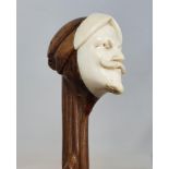 A 19th century walking stick, with ivory handle carved with the face of Mephistopheles, 90 cm