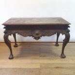 An 18th century style mahogany table, with a painted faux marble top above a shell carved frieze, on