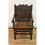 An oak Wainscot chair, with carved top rail, panel back and seat, on turned legs