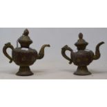 A pair of Tibetan gilt metal teapots (2) 20 cm and 18 cm tall