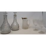 A pair of 19th century glass decanters, a cut glass jug and matching beaker with silver rim and