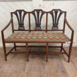 An unusual child's walnut chair back settee, with fleur de lys backs, a drop in seat and tapering