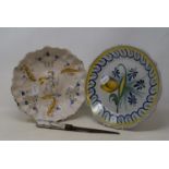 A 19th century Delft bowl, decorated with a cherub, a knife with Delft handle and Delft part