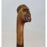 An early 20th century folk art cane, handle in the form of a Bedouin man, 89 cm