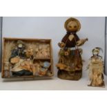 An early 20th century bisque peddler doll, with various baskets of wares, in glass dome, 30cm high