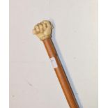 A 19th century mallacca cane, the finial carved as a clenched fist, length 81 cm