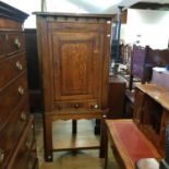 An oak corner cabinet, with a door above three drawers, 172 cm high