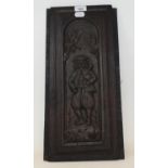 A carved oak panel with a figure holding bagpipes, 48 x 20 cm