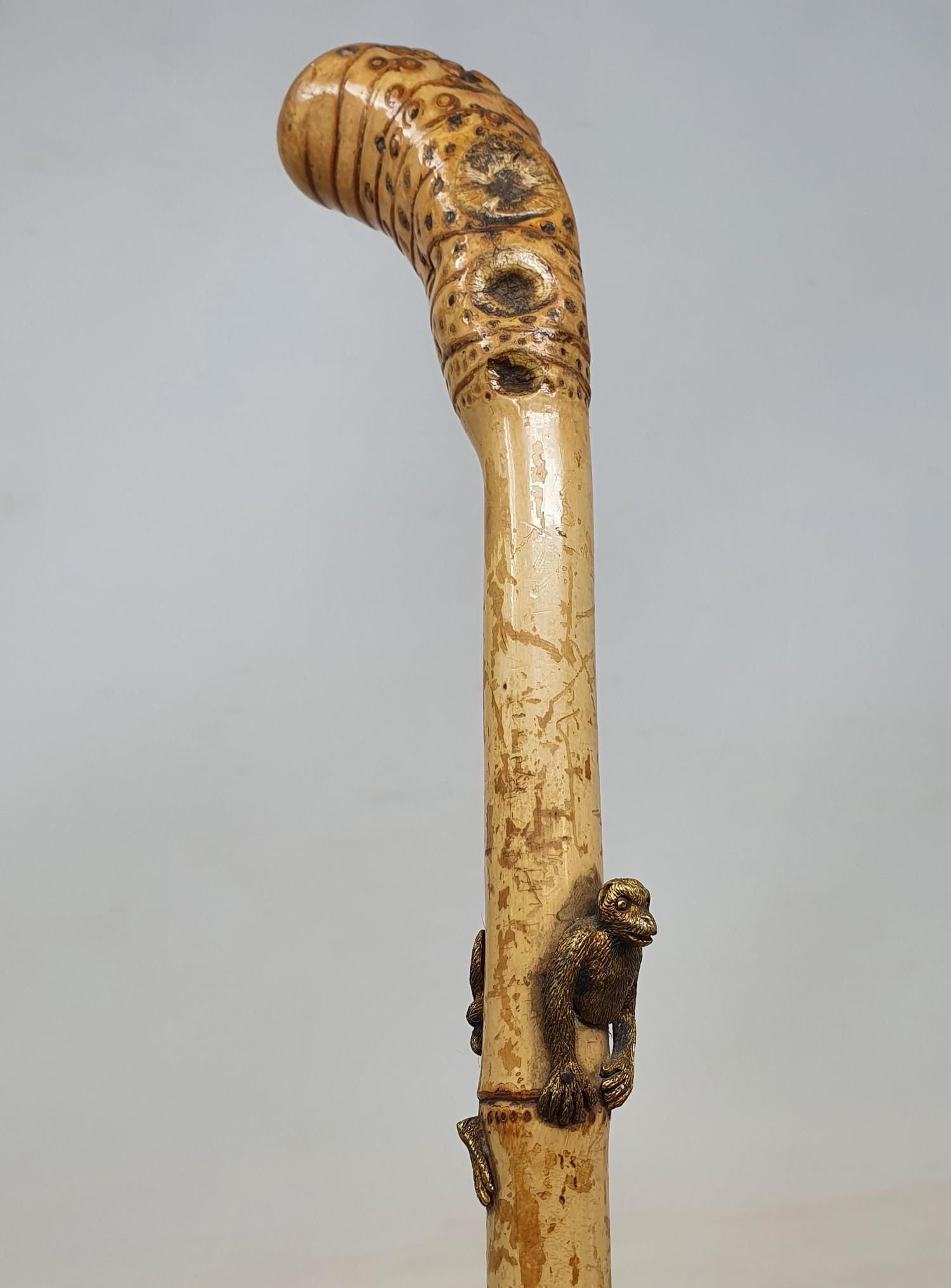 A 19th century bamboo cane inset with a brass monkey, 92 cm