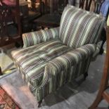 An Edwardian upholstered armchair, on tapering square front legs