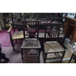 A set of four beech spindle back dining chairs, and a matching carver chair (5)