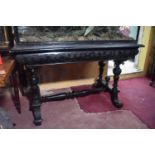 A Victorian ebonised table, on turned supports, wormed, 115 cm wide