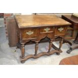 A walnut lowboy, with three drawers above a shaped apron, on turned legs joined by a shaped