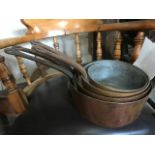 A graduated set of four copper saucepans