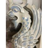 A wall mirror, in a painted frame, carved mythical beasts and foliage, 125 cm high x 94 cm wide