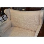 An Edwardian wing back two seater settee, on tapering square front legs, 120 cm wide
