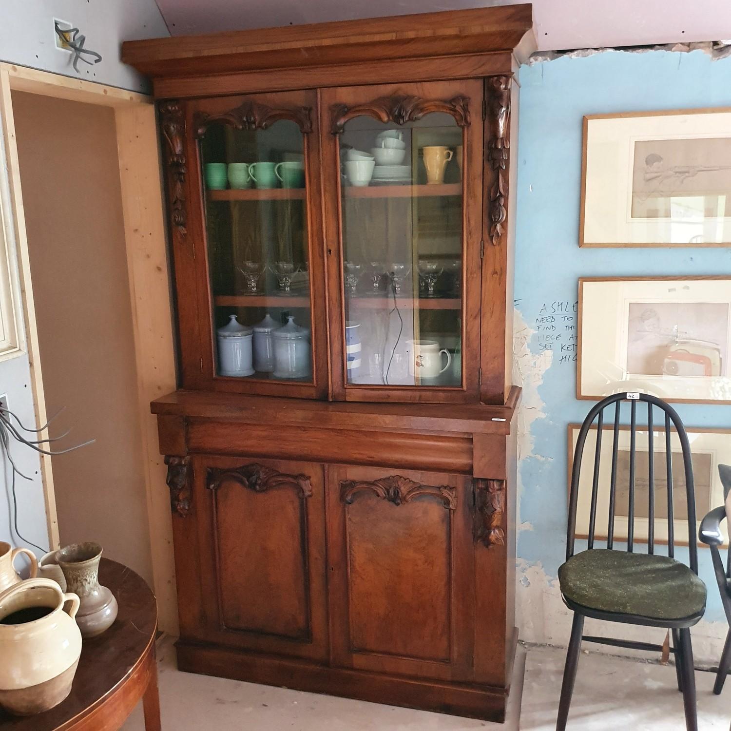 A late Victorian walnut bookcase, having a pair of glazed doors, above a drawer, with a pair of