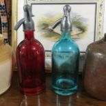 Five coloured glass Eau Gazeifiee syphons, a stoneware jar, and two stoneware jars and covers