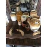 Assorted stoneware jars, a brass jug, and a set of deer hoof hooks