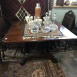 A 19th century mahogany drop leaf table, on a lotus leaf carved baluster column, concave sided