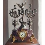 A French mantle clock, with a spelter angel figural finial, 64 cm high and a pair of matching