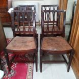 A set of four George III style mahogany dining chairs, with distressed leather drop in seats