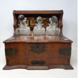 A 19th century oak three bottle tantalus, 37 cm wide and an Asian box, hinged front to reveal