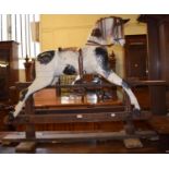 An early 20th century carved wood and painted rocking horse, 140 cm wide