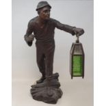 An early 20th century spelter lamp, in the form of a miner holding a lantern, 56 cm high