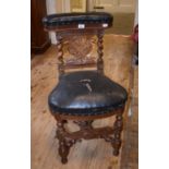 A late Victorian (pipe) smokers carved oak chair, the leatherette upholstered hinge back above a