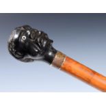 An early 20th century walking stick, with carved ebony handle, in the form of a man's head with