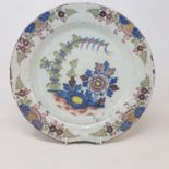 A 19th century Delft plate, decorated flowers, 34 cm diameter, another plate and blue and white