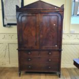 A 19th century mahogany linen press, the architectural pediment above a pair of panel doors, the