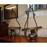A pair of early 20th century brass oil lanterns, converted to electricity, with opaque glass shades,