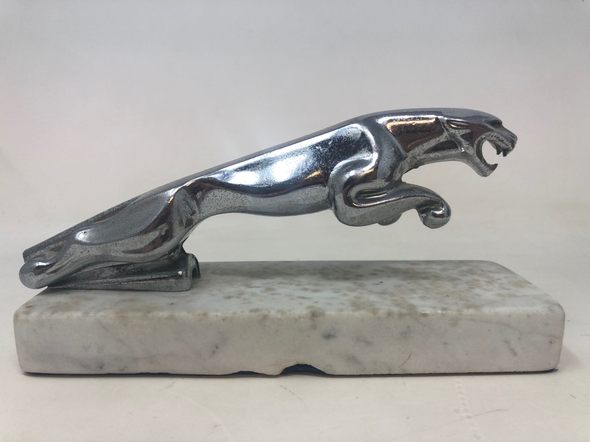 A chrome leaping Jaguar bonnet mascot, lacks tail, on a marble base, and two other hood ornaments - Image 5 of 6