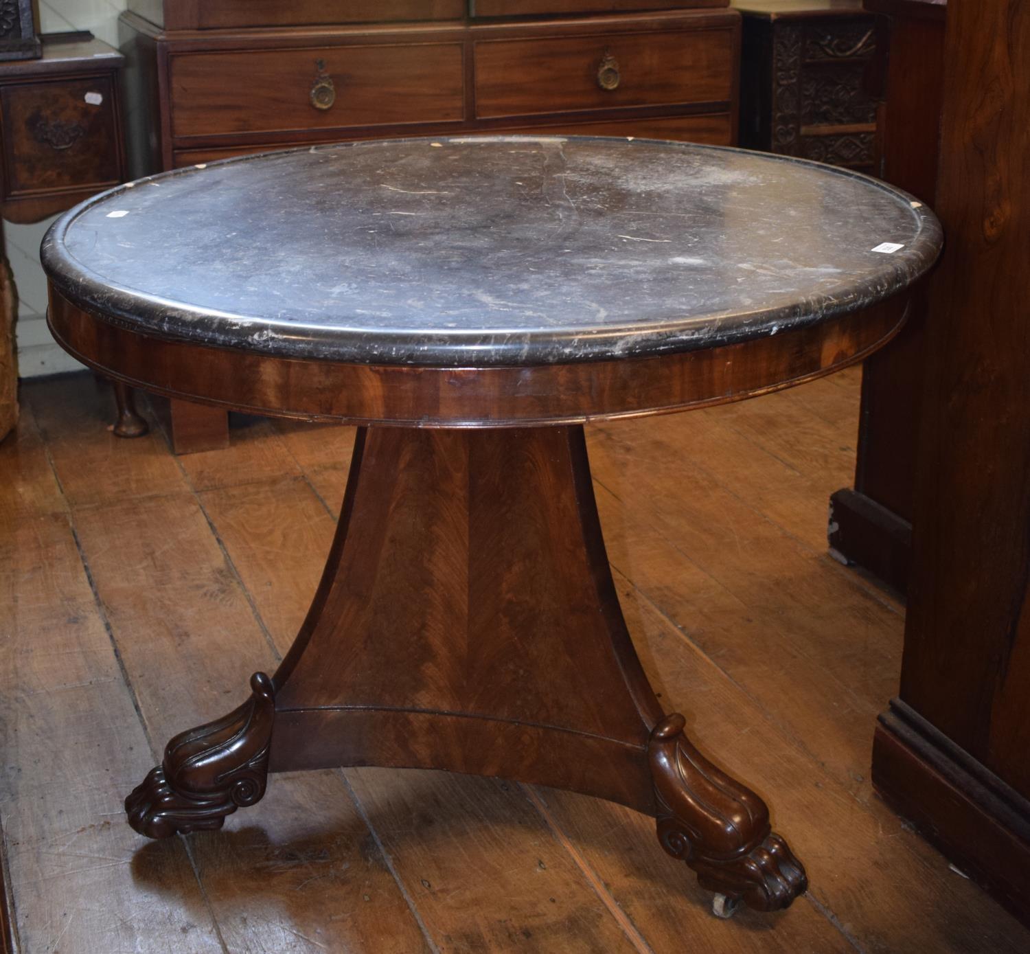 A French Guerridon, the dished marble top on a mahogany base, of tapering triangular form, with leaf