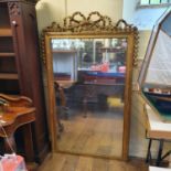 A French overmantel mirror, with a ribbon tie bow and bell flower surmount, 115 cm wide x 180 cm